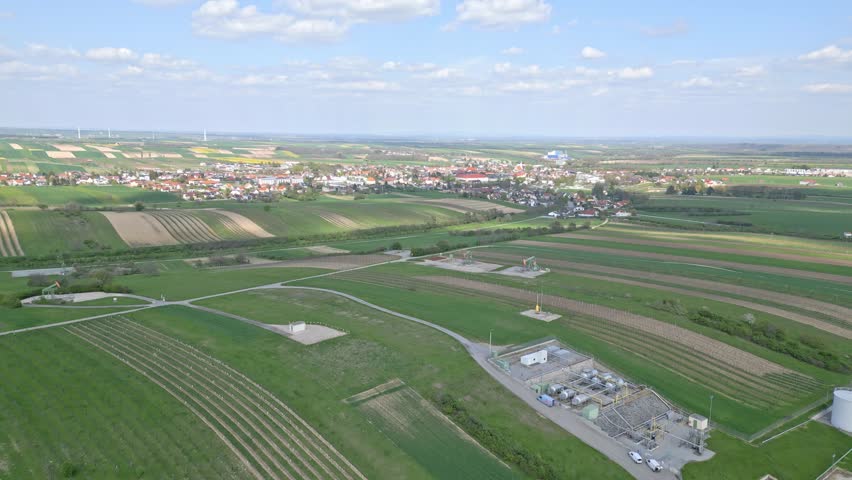 Aerial View Of Green Hills With Oil Derrick Near The Houses In Zistersdorf Town In Austria.