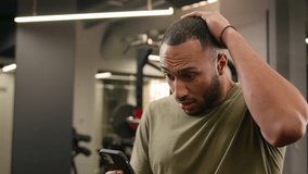 Sad upset stressed shocked loser African American fitness trainer guy sportsman male athlete bodybuilder man lost problem failure phone mobile trouble bad news online difficulties in sport club gym - Powered by Shutterstock - Get 15% off with code: PIKWIZARD15