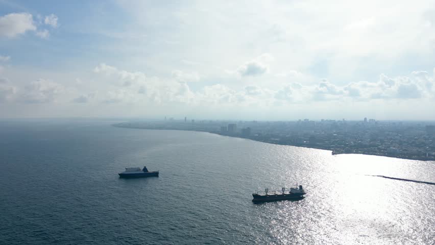 Two cargo tanker ships moored near a coastal city. Santo Domingo