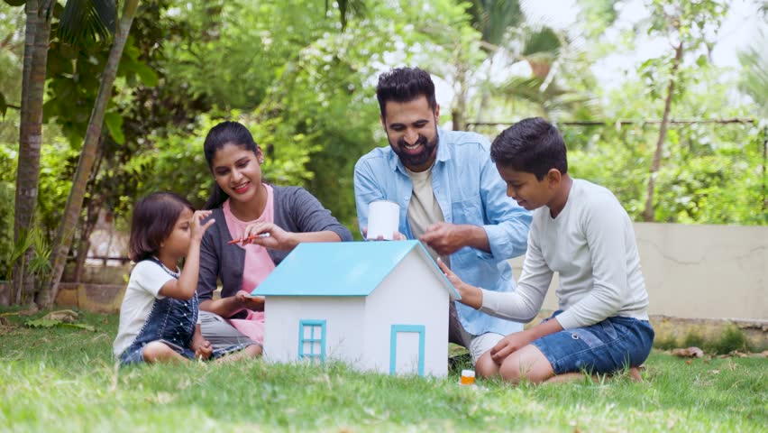 Happy indian parents helping kids to do painting on toy house at park - concept of Family art project, weekend holidays and Parental guidance. Royalty-Free Stock Footage #1104752367