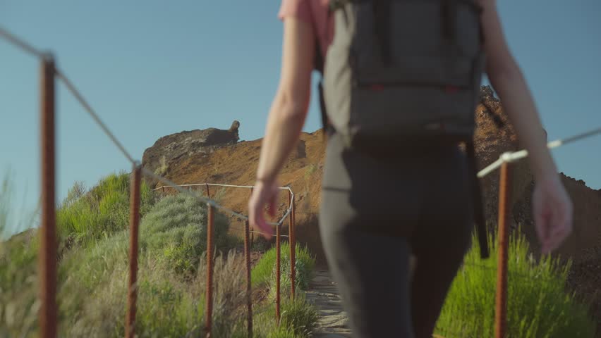 Blond woman with camera backpack walking on mountain trail in Madeira Royalty-Free Stock Footage #1104756223