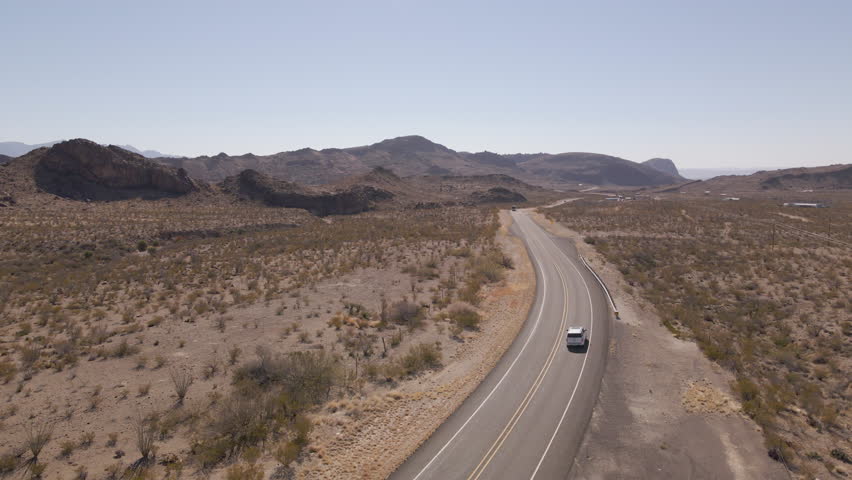 Aerial Shot of Vehicles on Highway Through Desert in Big Bend National Park in Texas, USA. Drone Shot car driving on the freeway in the desert of Big Bend.