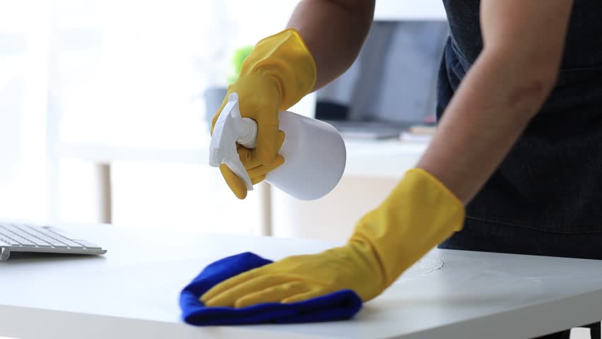 Person cleaning the room, cleaning staff is using cloth and spraying disinfectant to wipe the tables in the company office room. Cleaning staff. Maintaining cleanliness in the organization. Royalty-Free Stock Footage #1104759327