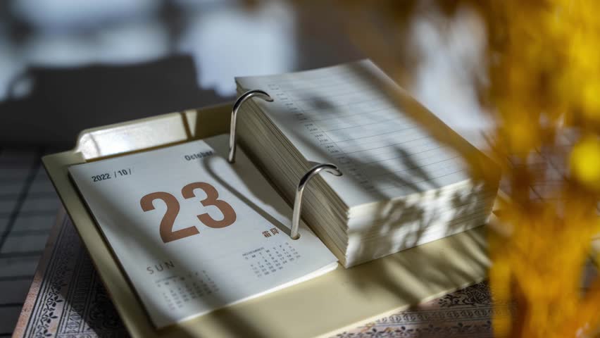 A time lapse of fast flipping of torn diary desktop calendar on the table with sunlight | Shutterstock HD Video #1104760237
