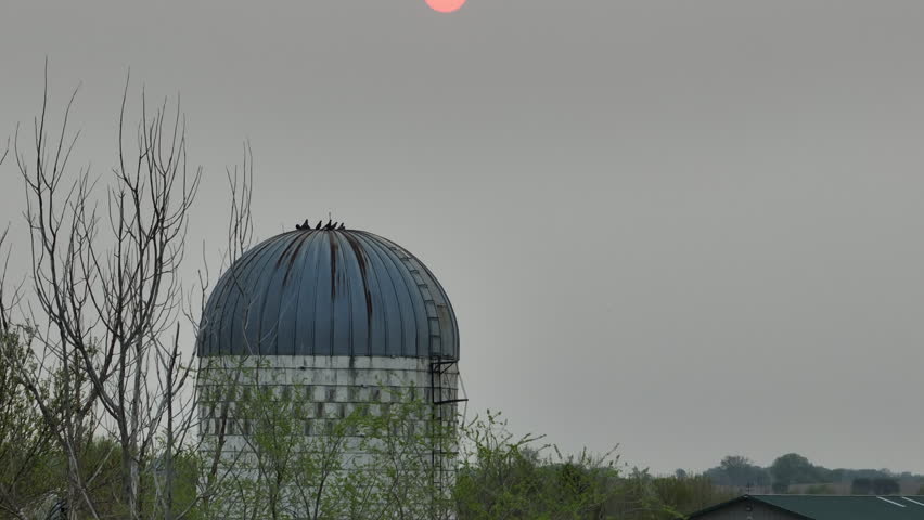 Grain silo in rural countryside, hazy sun in the background