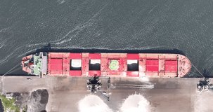 Top down view on a large cargo vessel moored at a metal factory.