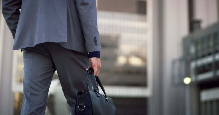 Legs, bag and back of business man walking, travel and on morning commute to law firm, office building or workplace. Lawyer briefcase, expert businessman and male attorney on outdoor city trip
