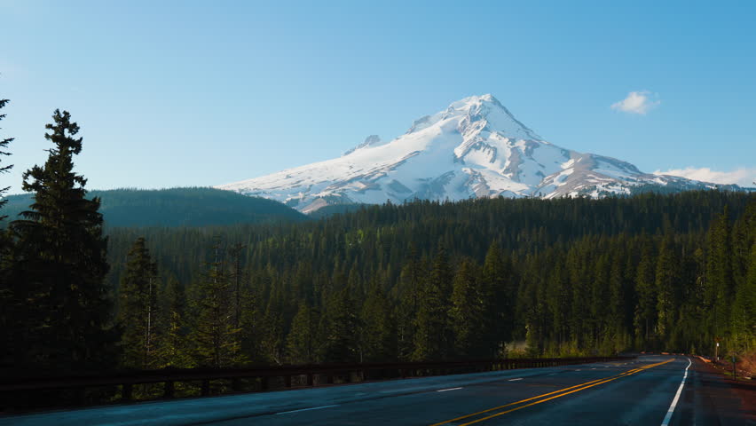 Mt Hood Oregon from highway road on a summer day with blue sky and clouds.