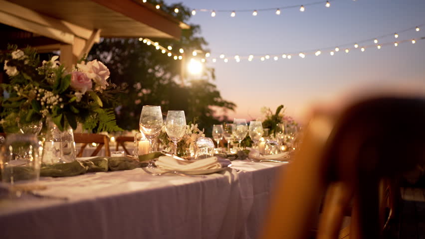 Dinner table setup sunset background. Close up decoration flowers candles Boho style.  Romantic wedding  reception party outdoor.    Royalty-Free Stock Footage #1104780113