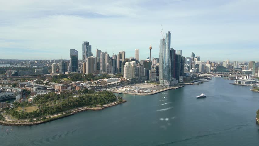 Breathtaking aerial footage of Sydney CBD, showing its iconic harbour, skyline, landmarks, and bustling city life. A Visual feast of urban beauty. Scenic aerial view pan left.