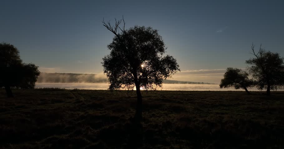 Fog on a lake. Aerial drone view over sunset lake. Peaceful reflection of the beautiful sunset lake. Landscape during the evening, greenery