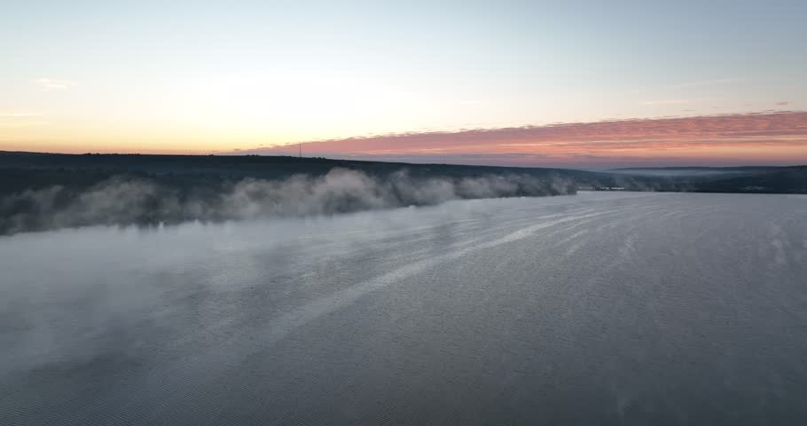 Fog on a lake. Aerial drone view over sunset lake. Peaceful reflection of the beautiful sunset lake. Landscape during the evening, greenery