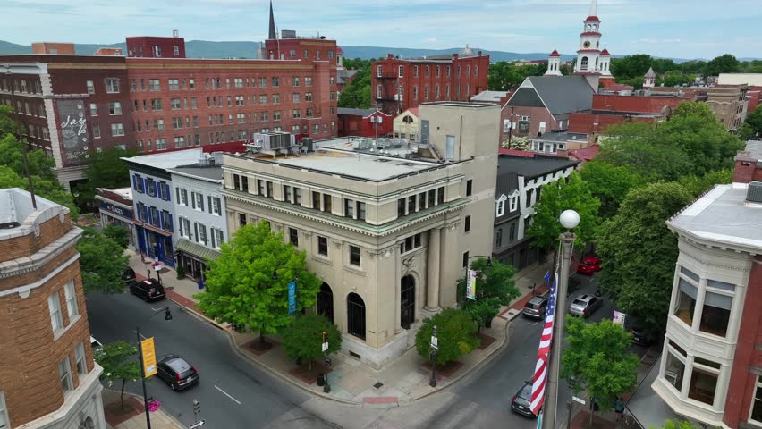 American USA flag in downtown city at Frederick Maryland. Rising aerial view.