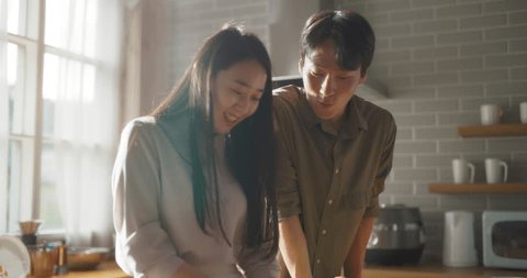 Portrait of a South Korean Young Couple Cooking at Home. Loving Boyfriend and Girlfriend Preparing Dinner in the Kitchen, Having a Funny Conversation While Cooking Delicious Food วิดีโอสต็อก