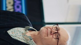 Vertical video Passioned client on black friday event searching for clearance items in clothing store, shopping center. Man discovers seasonal special offers deals on clothes, satisfied smile. - Powered by Shutterstock - Get 15% off with code: PIKWIZARD15