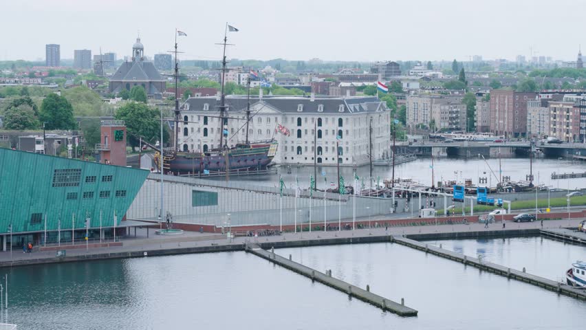 Skyline of the city Amsterdam in the Netherlands at the docks with a Dutch East India Company ship in the background