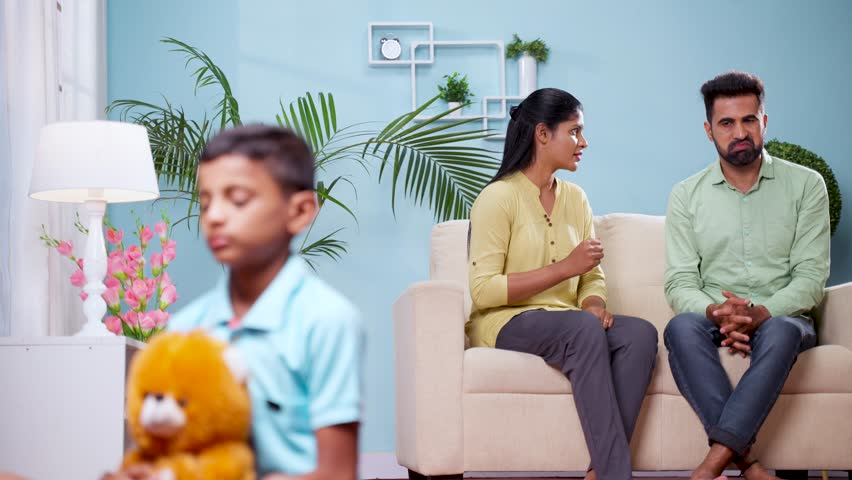 Rack focus shot, angry coulpe arguing in front sad kid at home - concept of family problems, disagreement and childhood trauma