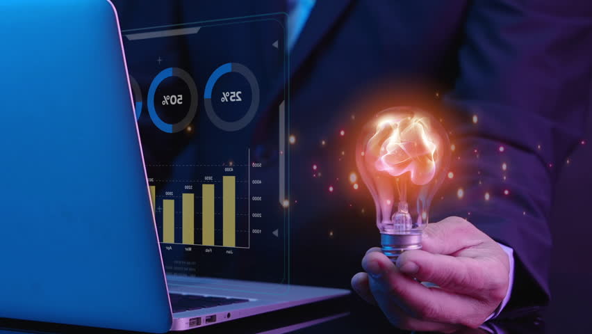 Businessman shows virtual chart and graph icon and abstract particle in light bulb, AI artificial intelligence, chatbot, machine learning concept, big data analytics, investment and financial concept - Powered by Shutterstock - Get 15% off with code: PIKWIZARD15