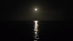 Flying over the ocean waves at night towards the bright moonlit sky. Night scene. - Powered by Shutterstock - Get 15% off with code: PIKWIZARD15
