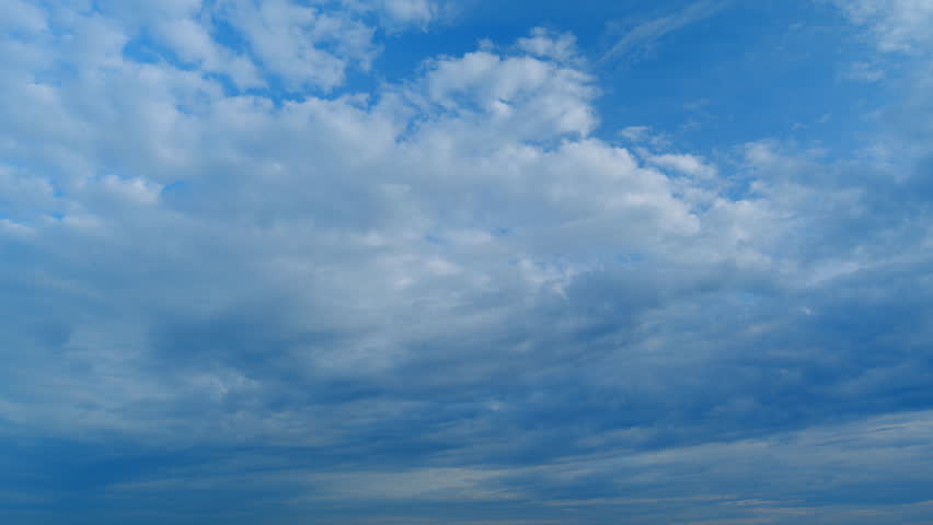 Flying moving white clouds in a blue sky. Blue sky background with many layers tiny clouds. Timelapse.
