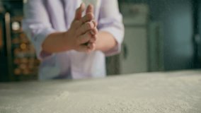 An experienced chef applies flour to his hands before making bread in a bakery prepares pastries in professional kitchen - Powered by Shutterstock - Get 15% off with code: PIKWIZARD15