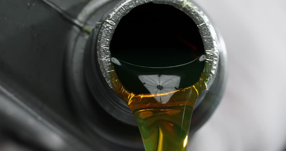 Transparent quality yellow oil is poured from plastic bottle