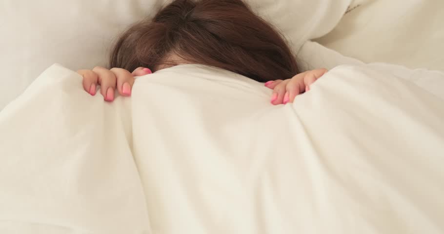 Playful Plus-Size Woman Looking from Blanket