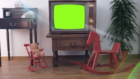 footage of Dated TV Set with white Screen Mock Up Chroma Key Template Display, Nostalgic living room with old rocking horse, children's toy, retro style Television, vintage family evening tv concept