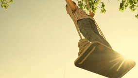 Happy boy swings while standing on swing in park against sky. Child plays on wooden swing, childrens ambition to fly, pilot flights into sky. Active Son is swinging on swing in park. Dream concept - Powered by Shutterstock - Get 15% off with code: PIKWIZARD15
