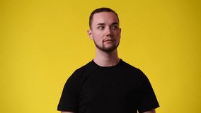 4k video of one man who closes the nose against the nasty smell over yellow background.