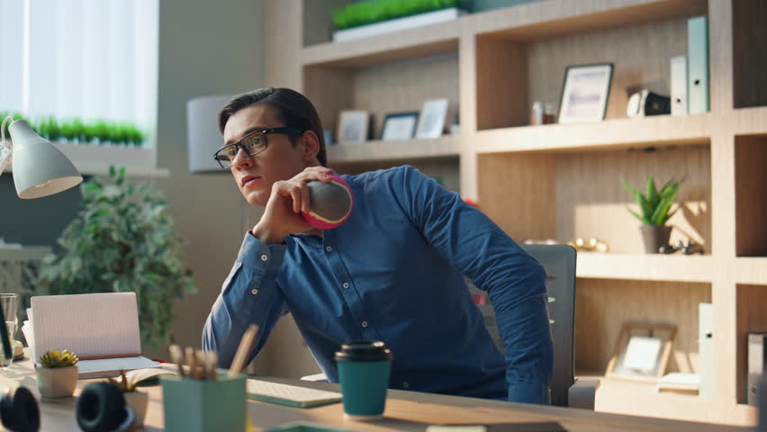 Relaxed freelancer tossing ball at office. Closeup pensive man taking work break relaxing at workplace. Calm creator checking notes playing indoor. Eyeglasses startuper looking computer resting alone | Shutterstock HD Video #1104814491