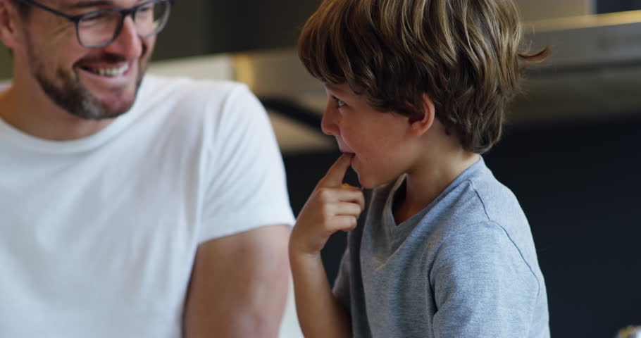 Baking, taste and father with child in kitchen learning cooking skills, child development and teaching to bake. Home, family and dad with son tasting mix for cake, food or snack for morning breakfast