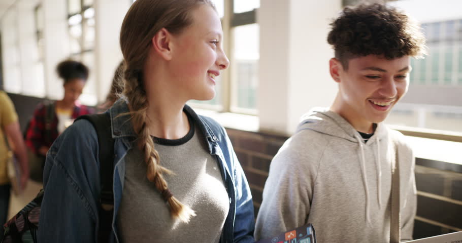 High school, students and friends walking in the hallway together for bonding after class. Happy, laughing and young boy and girl talking and having funny or teen conversation in corridor at academy