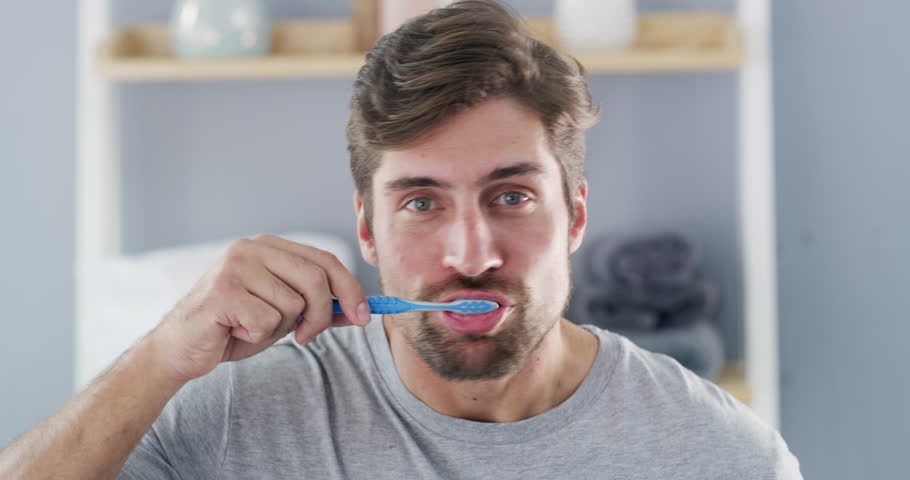 Dental, face and man brushing teeth with toothbrush in a bathroom for hygiene, wellness and fresh breath. Oral care, mouth and portrait of male cleaning tooth and gums with toothpaste in his home Royalty-Free Stock Footage #1104818791