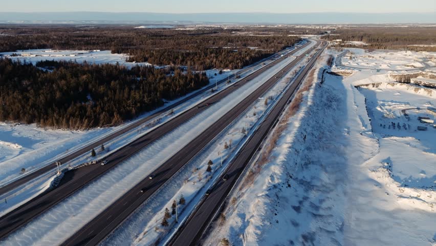 Drone shot of highway 7 leading toward the city of Ottawa Canada at sunset in winter