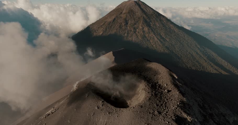Aerial Shot Of Fuego Volcano Erupting Volcanic Smog With Agua Volcano In Distance In Antigua, Guatemala. pan shot Royalty-Free Stock Footage #1104822443