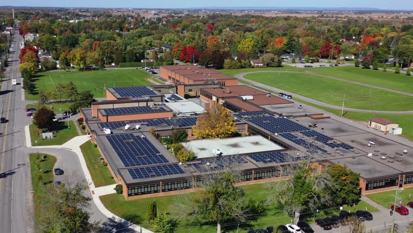 Drone shot of a small town high school in Canada with solar panels on the roof in Richmond Ontario