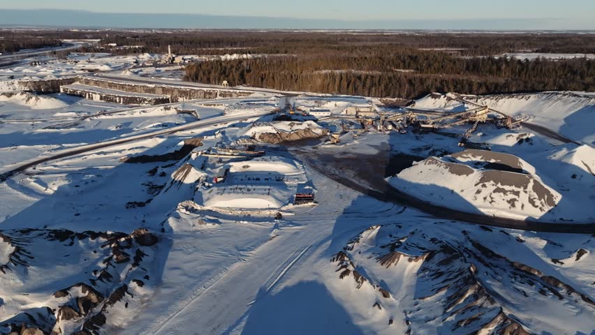 Mining equipment set up in a limestone quarry covered by snow during winter in Canada