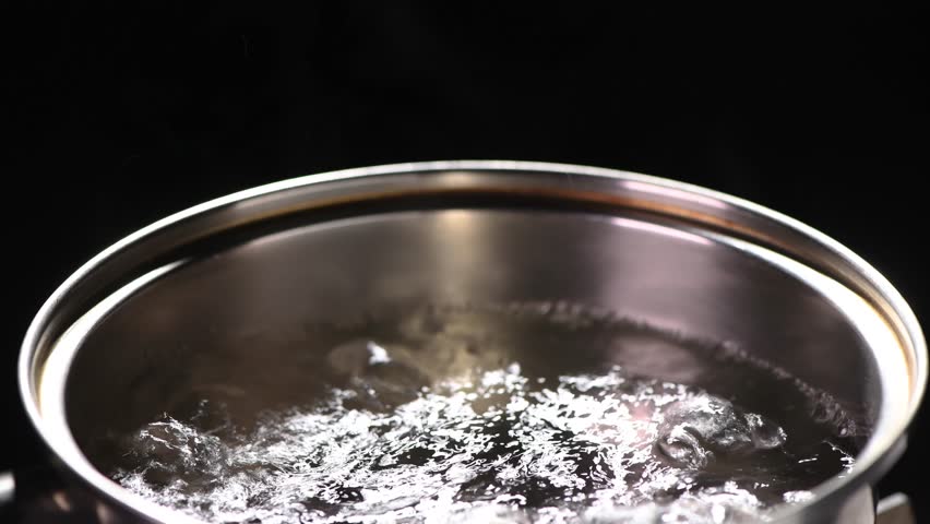 Steam rising from boiling hot water with black background Royalty-Free Stock Footage #1104825303