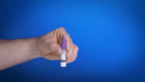 Break off violet plastic cap from buffer bottle with medical solution for home testing