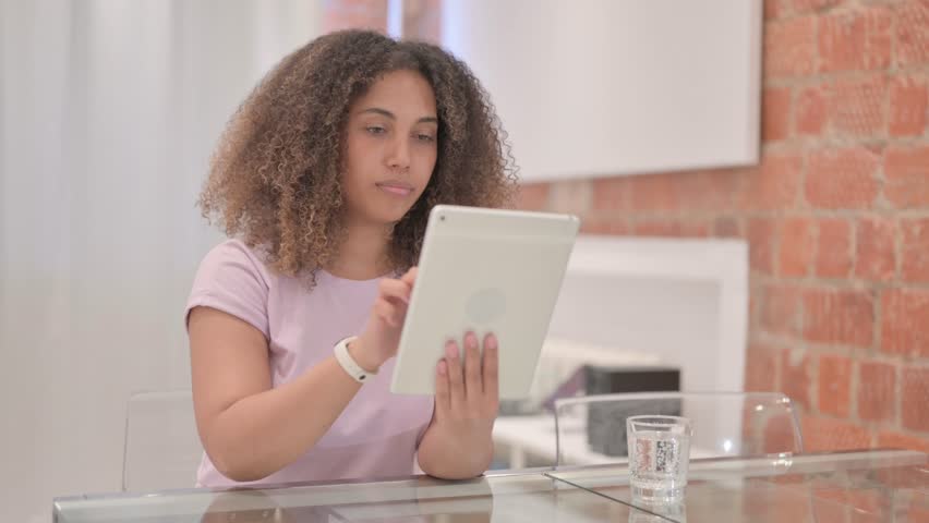 African American Woman Upset by Loss on Tablet