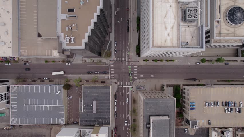 Drone descent to intersection in big city with tall buildings. Denver, Colorado. Transportation scene.