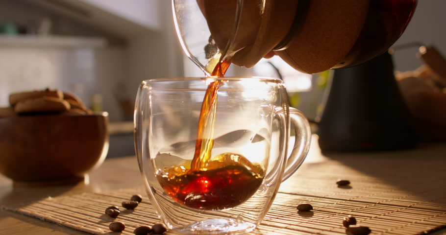 Close up of pour fresh brew coffee from chemex in glass cup mug in sun light