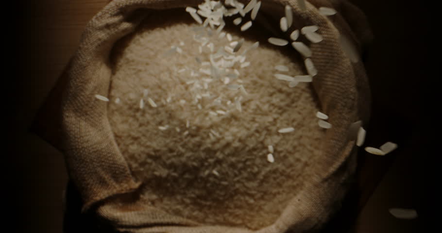 Rice grains fall into an open sack. Top view slow motion camera zoom. Concept healthy food organic products grown with love farmers canvas bag. Environmentally friendly farming nutrition education Royalty-Free Stock Footage #1104843193