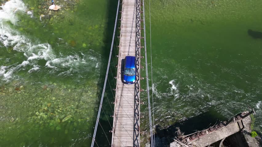 Drone flight over a wooden Tibetan suspended bridge that joins the river banks - view from the drone in Alagna Val Sesia Piedmont Alps mountains - travel concept journey in adventure natural trip  | Shutterstock HD Video #1104844877