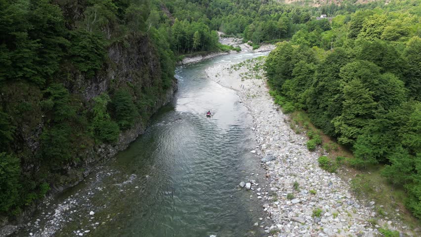 Go rafting on the river with dinghies immersed in the rapids of the stream and the nature of the canyon in Val Sesia Alagna Piedmont Alps mountains - drone view of summer water sport activities  | Shutterstock HD Video #1104844879
