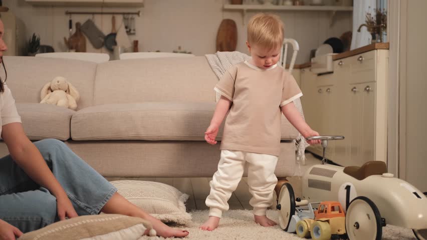 Happy family at home. Mother and baby boy playing with toys at home indoors. Little toddler child and babysitter nanny having fun together. Young woman mom kid son rest in living room | Shutterstock HD Video #1104847399