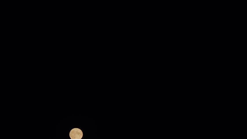 Full moon on dark night. Glowing yellow huge full moon as seen from earth. Timelapse. | Shutterstock HD Video #1104847649