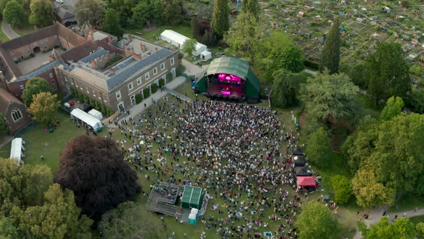 Circling aerial shot over concert panning up to the London skyline Royalty-Free Stock Footage #1104848953