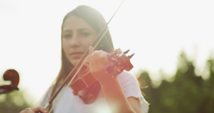 Young girl, instrument and violin player outdoor with music talent in nature park. Female person, bokeh and youth musician with creativity and student confidence with musical object in backyard Royalty-Free Stock Footage #1104849777